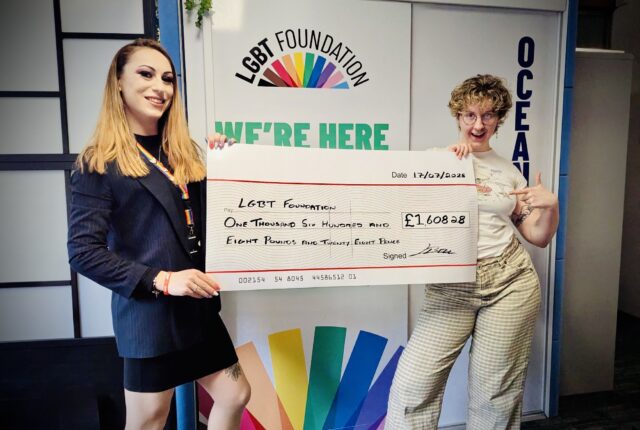 Lizi Bell from IWS Water Hygiene standing with a cheque with a representative from the LGBT Foundation